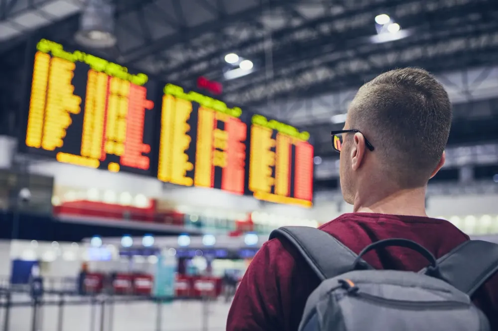 man looking at canceled flight board.